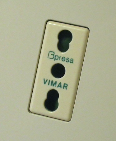 A picture of a Bipasso socket, which accepts both 10A and 16A plugs. The line and neutral holes are shaped specifically to be able to accomodate both.