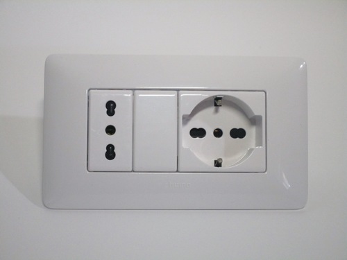 Italianised Schuko socket. It has holes that can accept both types of Italian plugs, as well as earth contacts for Schuko plugs.