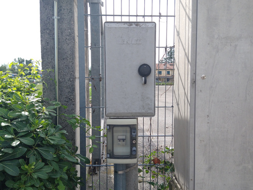 A power meter box outside, closed. Below it there's a small enclosure with a breaker, protecting the installation.