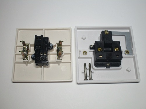 Rear view of the sockets. The Italian socket uses claws to hold onto the wall box, while the British one uses screws.