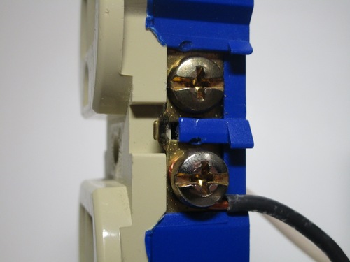 Wire terminals on a US socket. The wire is bent around on the screws.