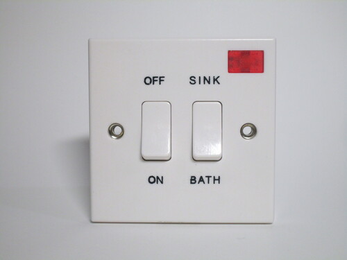 Immersion heater switch. There's a switch labelled 'on' and 'off' and one selecting between 'sink' and 'bath'. A red indicator light is also present.