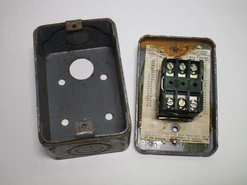 Internals of the switch. The mechanism itself is held on the front cover. An information sheet is present underneath it.