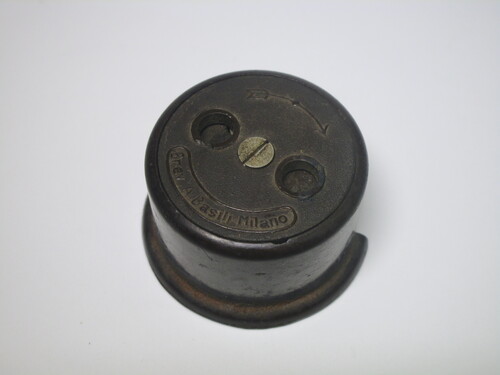 Front view of the mystery socket. A shutter is present, with arrows indicating to turn it clockwise to open it.