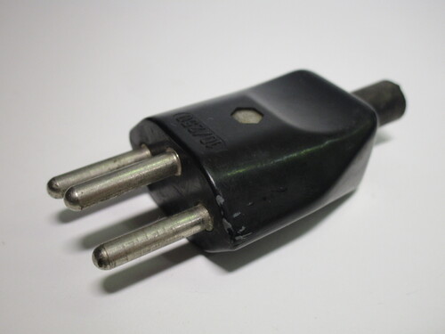 Front view of the old Swiss T12 plug. It has three round pins without any sleeving.