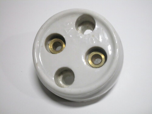 Vintage ceramic socket with exposed contacts that can be easily touched.