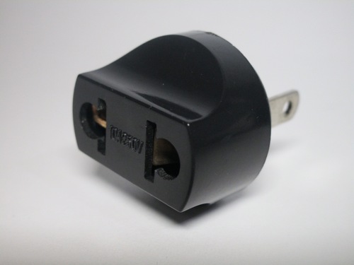 Front view of the adaptor. The plug holes are large and don't have shutters, making it possible to touch the live contacts.